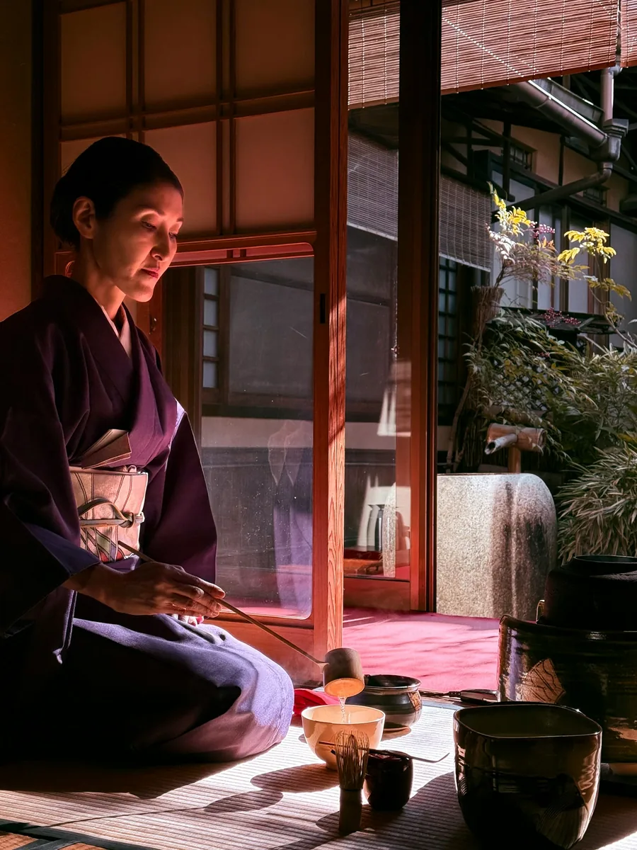 A tea ceremony host preparing ceremonial-grade matcha in a traditional Japanese room